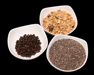 a set of spices in white bowls
