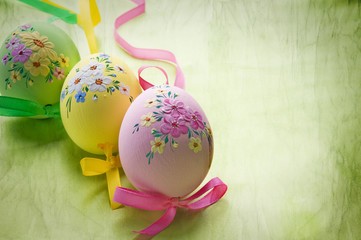 three colorful Easter eggs with flower decoration over grunge vintage background