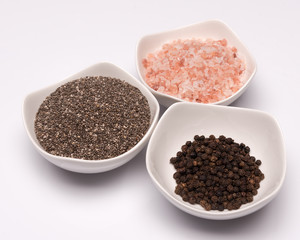 a set of spices in white bowls
