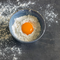 Eggs and flour in the blue bowl. Ingredients for home baking. Delicious Breakfast.
