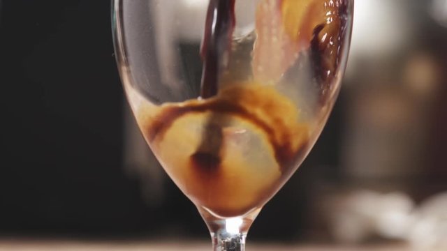 Slow motion closeup of pouring coffee into glass