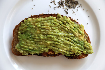 Avocadocreme auf getoastetem Brot auf weißem Teller