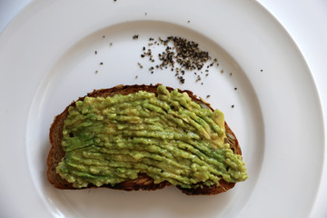 Avocadocreme auf getoastetem Brot auf weißem Teller