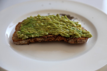 Avocadobrot auf weißem Teller
