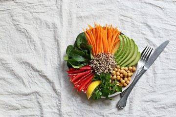 
    Quinoa salad with fresh vegetables,avocado and chick pea. Buddha bowl with quinoa, spinach and chopped vegetables. Healthy eating and super food concept.Overhead view 