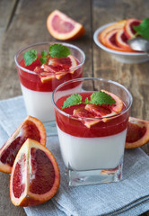 Panna cotta with red orange jelly on a wooden table 