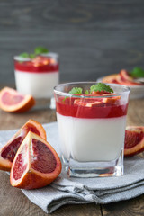 Panna cotta with red orange jelly on a wooden table 