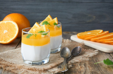 Panna cotta with orange jelly on a wooden table