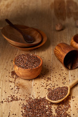 Wooden spoon with flax seeds on rustic background, top view, close-up, shallow depth of field, selective focus