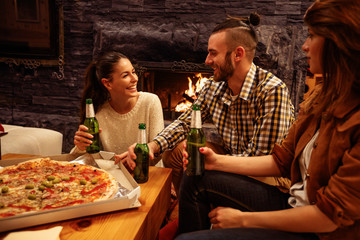 Smiling people in casual clothes eating pizza and drinking