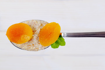 spoon of oatmeal porridge with apricots