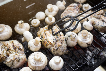 Turning Pieces Of Hot Outdoor BBQ Grill With A Lot Of Mushrooms And Tasty Chicken Breast Meat