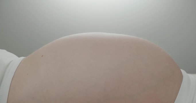 the belly of a pregnant woman wiggling child, close up