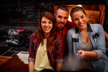 Time of relaxing after skiing- friends making selfie together