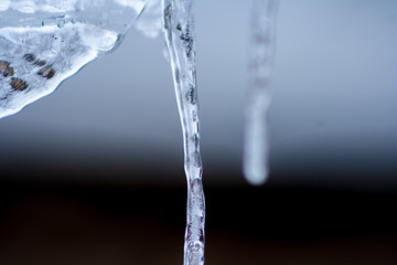 Close up of shiny and blue icicles with a dark background
