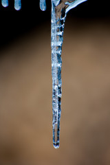 Close up of shiny and blue icicles with a dark background