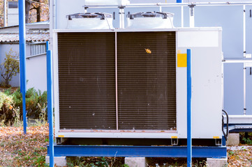 Gray commercial cooling unit for central ventilation system with big ventilation unit standing...