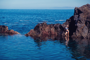 beautiful girl resting in natural ocean swimming pool