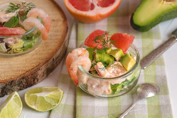 Cocktail salad with shrimp, avocado, green lettuce, grapefruit and mayonnaise sauce in a glass.