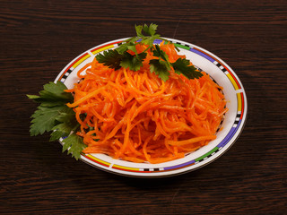 Carrots finely chopped and parsley on a plate on the table.