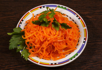 Carrots finely chopped and parsley on a plate on the table.