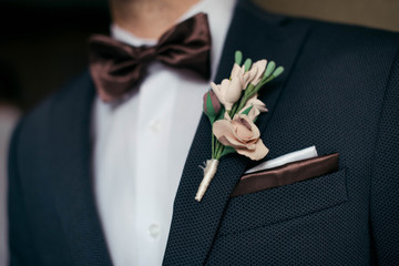Close-up of the the groom boutonniere, butterfly, wedding handkerchief in the pocket