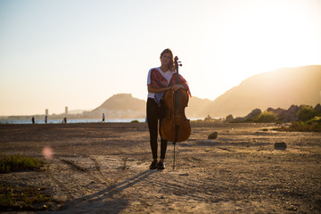 Young beautiful girl with her cello on the outside © luismolinero