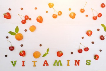 Color inscription Vitamins. Fruits and copy space.White background. Food concept