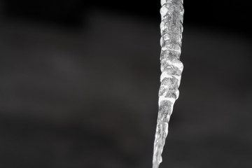 Close up of shiny and white icicles with a dark background