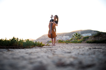 Young beautiful girl with her cello on the outside © luismolinero