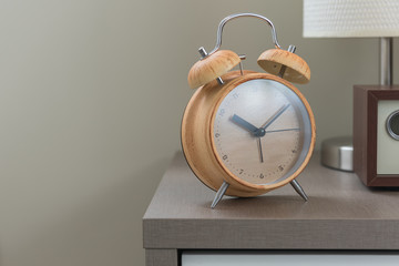 wooden modern alarm clock on bed