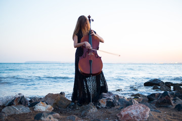 Young beautiful girl with her cello on the outside © luismolinero