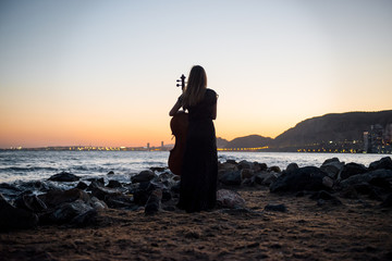 Young beautiful girl with her cello on the outside © luismolinero