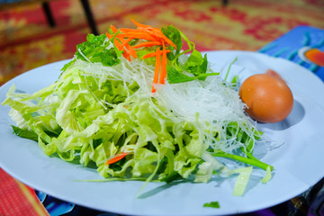 Egg, vegetables and vermicelli in blue dish