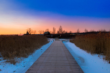 early sunrise at sunny winter day with reeds and snowy firld at background