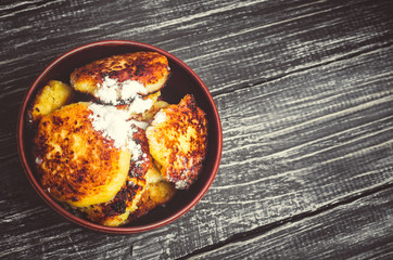 sweet cheese pancakes on a plate on a wooden background, syrniki.  Ukrainian and Russian cuisine. cottage cheese food. top view, place for text