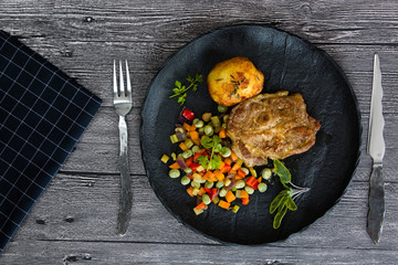 Grilled pork with roasted vegetables and baked potato