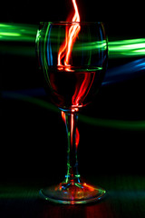 A glass of wine on a bright background with a bokeh effect.