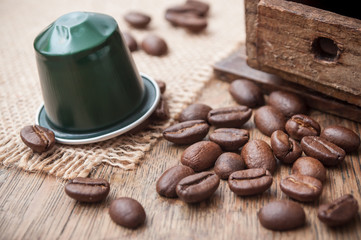 dosette de café expresso avec grains de café et ancien moulin à café décoratif sur sur table en bois - obrazy, fototapety, plakaty
