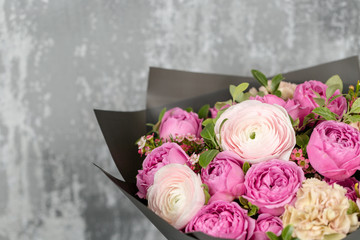beautiful bouquet of mixed flowers into a vase on table. the work of the florist at a flower shop. Copy pace