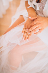 Fototapeta na wymiar Bridal morning preparation. Wedding ring on bride's hand. Artwork. Selective focus on the wedding ring. Close-up