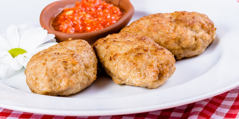 Beef cutlets with tomato sauce on white plate