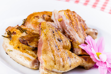 Grilled chicken with spices and herbs on white plate