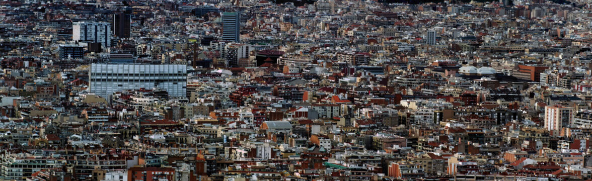 panoramic aerial cityscape view of the barcelona cityscape showing densely crowded buildings towers and streets