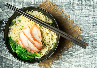 noodle in bowl on wood background top view.