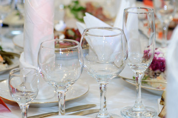 Empty wine glasses on the food table. Restaurant table setting for eating and drinking. 