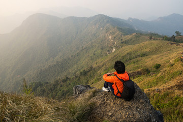 Young traveler sitting and looking at beautiful landscape