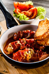 Grilled sausages with toasts on wooden table 