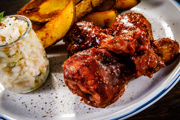 Barbecued chicken drumsticks with chips and vegetables 