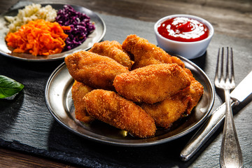     Chicken nuggets with vegetable salad on wooden table 